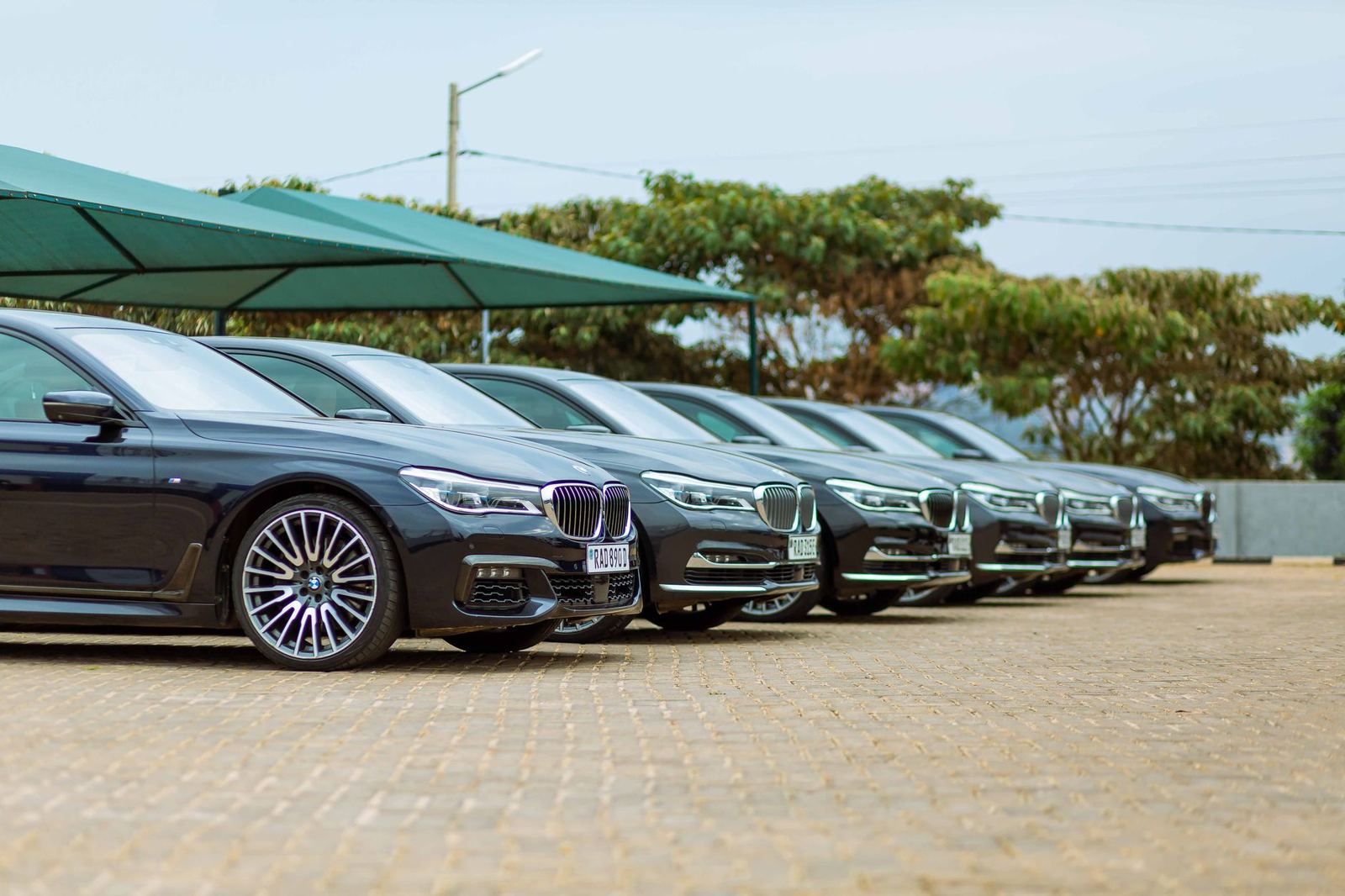 A row of dark executive saloons parked under cover